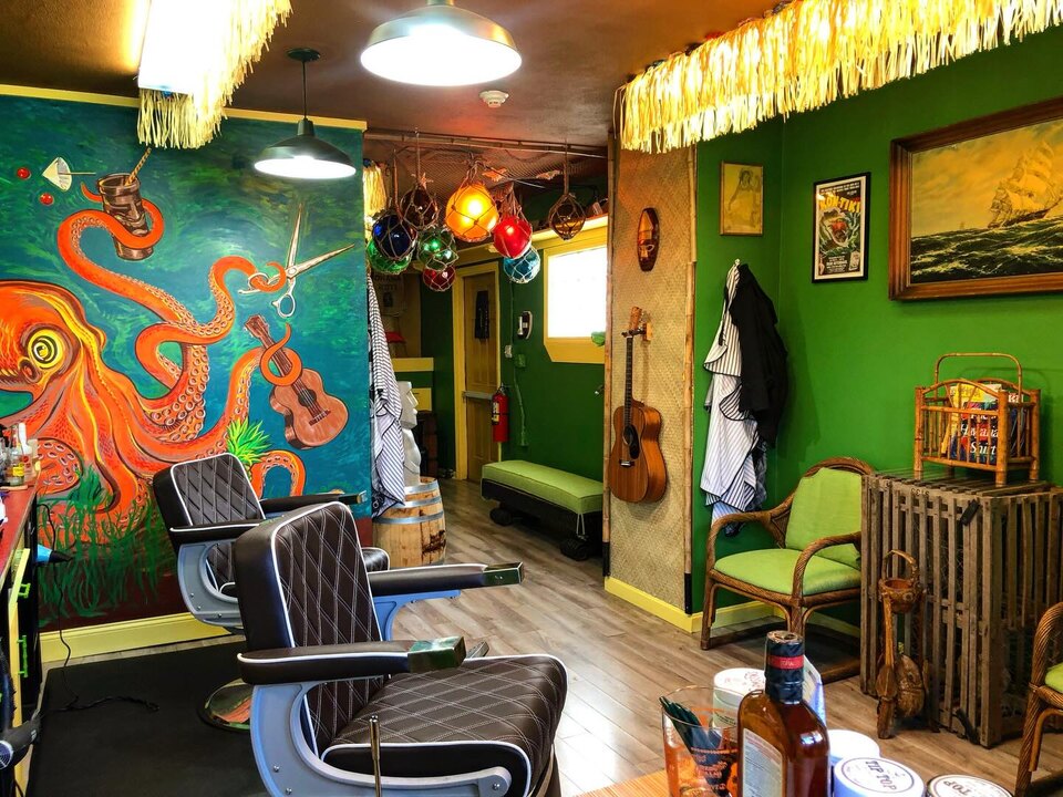 Interior of Jack's Barber Shack barbershop — tiki bar, vintage jukebox, and guitars in Manchester-by-the-Sea, MA